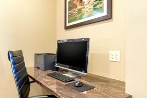 a desk with a computer monitor and a keyboard and mouse at Comfort Inn & Suites Page at Lake Powell in Page