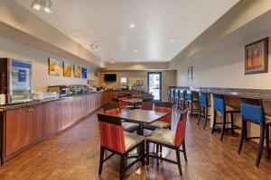 een restaurant met tafels en stoelen en een bar bij Comfort Inn & Suites Page at Lake Powell in Page