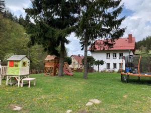 a yard with a house and a playground at Willa Weronika in Miedzygorze