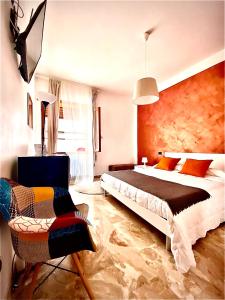 a bedroom with a large bed and a chair at B&B mò•sì in Massa dʼAlbe