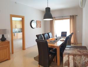 a dining room with a table and chairs and a clock at Luxury Villa Corcovada Nicole with privat heated pool in Albufeira