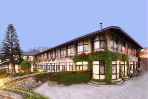 a large building with flowers in front of it at The Elgin Silver Oaks - Heritage Resort & Spa in Kalimpong