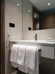 a bathroom with a sink and towels on a tub at Hotel 3K Faro Aeroporto in Faro +25 photos