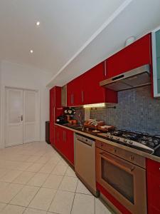 a kitchen with red cabinets and a stove top oven at Glory House Trastevere in Rome