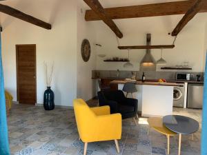 Sala de estar con silla amarilla y mesa en Casa Valinco en Propriano