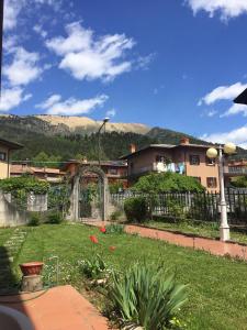 a yard with a fence and a garden with flowers at Villa Romeo - Acero Rosso in Rovetta