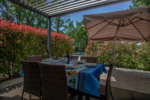 - une table avec un parasol sur la terrasse dans l'établissement Belvillas, à Montauroux