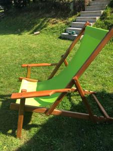 a green and wooden chair sitting on the grass at Golija Vikendica Česta Vrela in Raška