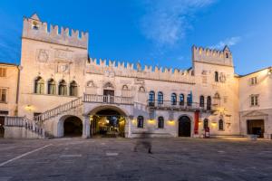 an old building with a tower and a staircase in a courtyard at Guest House Via Flavia in Koper