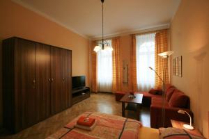 ein Wohnzimmer mit einem roten Sofa und einem TV in der Unterkunft Apartment No. 19 Jaltská 3 in Karlsbad