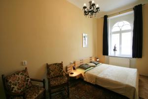 ein Schlafzimmer mit einem Bett, einem Fenster und einem Stuhl in der Unterkunft Apartment No. 20 Jaltská 3 in Karlsbad