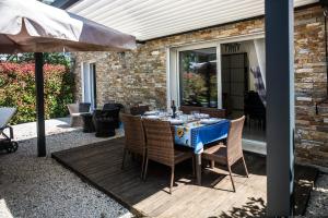 een patio met een tafel met stoelen en een parasol bij Belvillas in Montauroux