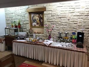 a long table in a room with a stone wall at Hotel Merlot in Opuzen