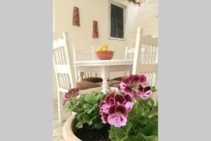 a porch with a table and chairs and flowers at Skiathos Town House in Skiathos