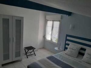 Un dormitorio con una cama azul y blanca y una ventana en Le Domaine Leylandy, en Saint-Sulpice-de-Royan