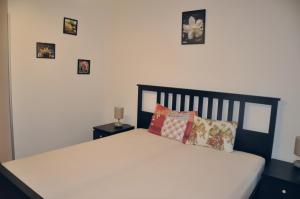 1 dormitorio con 1 cama con 4 cuadros en la pared en Apartment No. 40 Stará louka 20, en Karlovy Vary