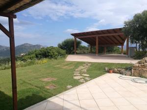 a pavilion in a garden with mountains in the background at Lu Nidu in Olbia