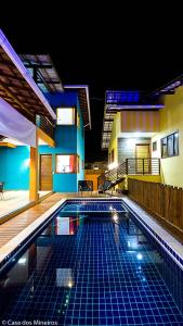 a swimming pool in front of a house at night at Casa dos Mineiros in Arraial d'Ajuda