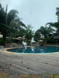 a large swimming pool with chairs and umbrellas at Sítio do Bosco Park in Tianguá