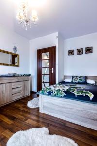 sypialnia z łóżkiem, komodą i lustrem w obiekcie Apartament Tatry Jaszczurówka w Zakopanem
