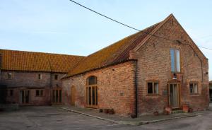 un antiguo edificio de ladrillo con un techo puntiagudo en The HopBarn, en Hockerton