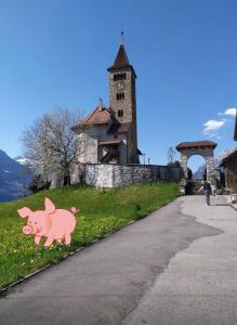 un panneau de porc rose sur le côté d'une route dans l'établissement Homestay Brienz, à Brienz