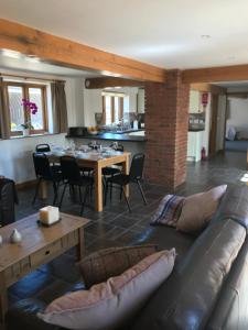 a living room with a couch and a table and a kitchen at The HopBarn in Hockerton