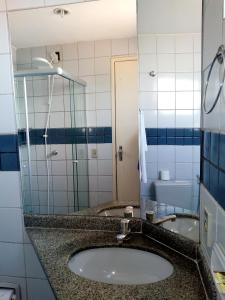 y baño con lavabo y espejo. en Hotel Nacional Service, en Goiânia