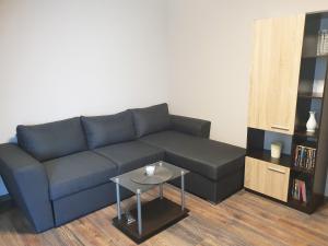 uma sala de estar com um sofá azul e uma mesa em Апартамент БОНИТА em Haskovo