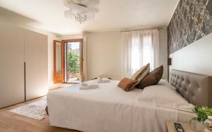 a bedroom with a large white bed with a window at Hotel Grifoni in Venice +82 photos