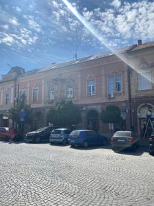 a large building with cars parked in front of it at Apartment suite Mukachevo in Mukacheve