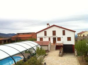une maison blanche avec une piscine en face de celle-ci dans l'établissement Refugio La Covatilla I,II,III y IV, à La Hoya