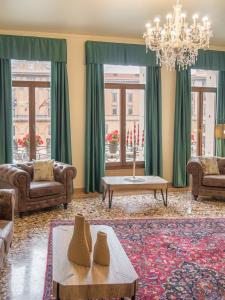 a living room with couches and a chandelier at Grand Canal Suite by Wonderful Italy in Venice