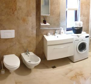 a bathroom with a toilet and a sink and a washing machine at Star Apart in Râmnicu Vâlcea