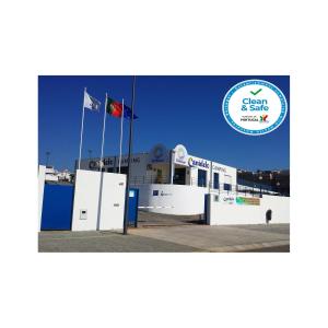 a building with two flags on top of it at Parque de Campismo Orbitur Canidelo in Vila Nova de Gaia