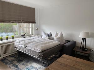 Schlafzimmer mit einem großen Bett und einem Fenster in der Unterkunft Sylthaus - Appartement in Archsum