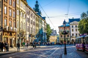 a city street with people walking and a tram at Апартаменти з сучасним ремонтом на площі Митній in Lviv