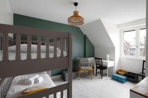 - une chambre avec des lits superposés et un bureau dans l'établissement Villa du Marché by Cocoonr, à Dinard