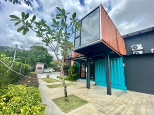 a house with a blue facade with a wooden roof at Reserve The Cozytainer in Taiping