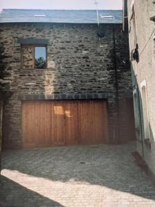 un garaje con puertas de madera y un edificio de ladrillo en Moss Tarn, en Ulverston