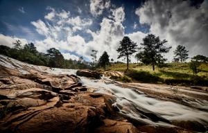 a stream of water in a river with rocks at Silverstone Lodge in Mbabane