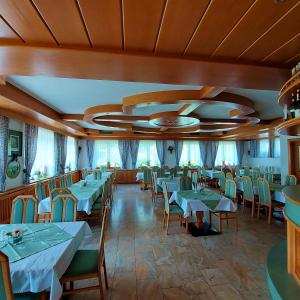 um restaurante com mesas e cadeiras e um tecto em Landgasthof Hasbauer em Klein Sankt Paul