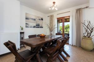 ein Esszimmer mit einem Holztisch und Stühlen in der Unterkunft Adonis Villa in Dassia