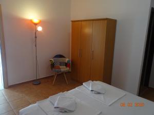 1 dormitorio con 2 camas, armario y silla en Apartments Antea & Magdalena en Pirovac