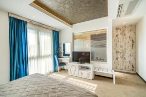 a bedroom with a bed and a television on a table at Boutique Hotel "Salina" in Ulcinj