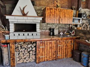 cocina con chimenea y encimera con fregadero en Camere de inchiriat La Locanda, en Dubova 32 fotos más