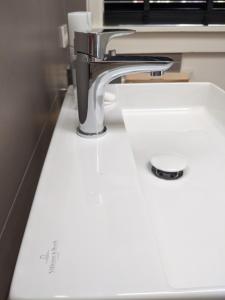 a sink in a bathroom with a faucet at Beachtime Suite in Zandvoort