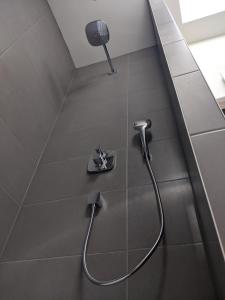 a shower in a bathroom with a hose on the floor at Beachtime Suite in Zandvoort +22 photos