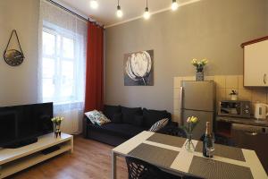 uma sala de estar com um sofá e uma mesa em KGHN Apartments Tkacka 11 em Szczecin