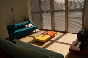 een woonkamer met een bank en een salontafel bij Sfeervol rustige loft in Oostende